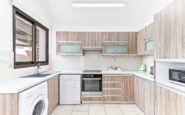 Modern kitchen interior with wooden cabinetry, stainless steel appliances, and ample counter space.