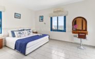 Kissonerga Villa Cozy and serene nautical-themed bedroom with blue accents and ocean view.