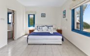 Kissonerga Villa with Modern and bright bedroom with clean design, featuring a made bed and natural light.