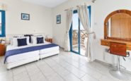 Kissonerga Villa with Minimalist and serene bedroom with white, blue, and wooden decor elements for relaxation.