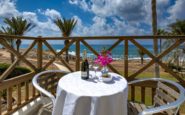 Kissonerga Villa with Seaside balcony retreat with wine and flowers overlooking a tranquil beach.