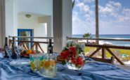 Kissonerga Villa Luxurious coastal dining setup on veranda overlooking ocean view.