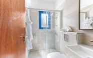 Modern, compact bathroom with glass shower, minimalist fixtures, and natural light.