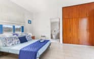 Holiday Villas in Paphos with Modern bedoom with blue accents, minimalist decor, and ample natural light.