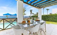 Modern outdoor dining area overlooking pool and seafront at Daphne Holiday Villa in Paphos