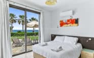 Villas for rent with coastal bedroom with ocean view, minimalist decor, and modern amenities.