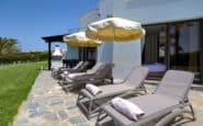 Villa Hire Cyprus with modern outdoor lounge chairs with umbrellas, perfect for relaxation and sunbathing