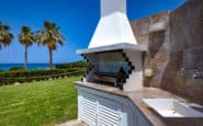 Villas for rent with Luxurious coastal barbecue area with sea view, palm trees, and modern amenities.