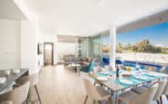 Modern open-plan living and dining space in holiday rentals in Cyprus Protaras with sleek decor and outdoor view.