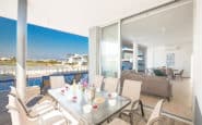 Modern indoor and outdoor living space with poolside dining and waterfront view in holiday rentals in Cyprus Protaras