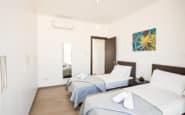 Modern twin bedroom with stylish decor, vibrant artwork, and minimalist design in holiday rentals in Cyprus Protaras