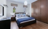 Cozy and stylish contemporary bedroom with blue and white accents, elegant design and ample storage.