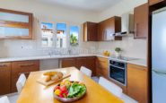 Kato Paphos Villa with Bright and modern kitchen with wooden cabinets, sleek design, and natural light.