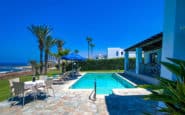 Luxurious coastal holiday villa in Paphos, Cyprus with pool, outdoor dining area, and ocean view.