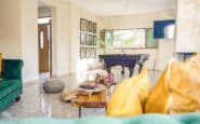 Open living room at Villa Aura, with green sofas and a pool table