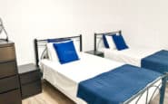 Twin bedroom with blue accents at Villa Palms View in Limassol.