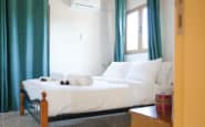 Double bedroom at Villa Aura in Nicosia with white bedding and green curtains