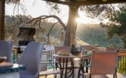 Outdoor dining area at Villa Aura in Nicosia with a barbecue grill at sunset