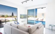 Luxurious living room with outdoor pool view in modern Cyprus villa rental.