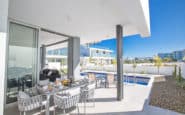 Modern outdoor living space with dining area, poolside, and contemporary design in Protaras.