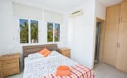 Bright and airy double bedroom with palm tree view in Protaras villa rental.