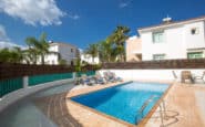 Luxurious pool area with sun loungers and palm trees for holiday rentals in Protaras, Cyprus.