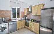 Modern kitchen with stainless steel appliances, wooden cabinets, and natural light.