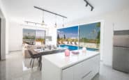 Modern open-concept kitchen and living area in a luxury villa rental with sleek design.