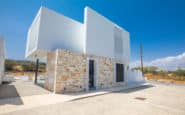 Modern Cyprus Villas Rentals minimalist in semi-arid setting with stone base and sleek white upper level.