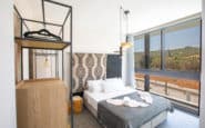 Cyprus Villas Rentals with Modern bedroom with grey accents, geometric headboard, and natural light.