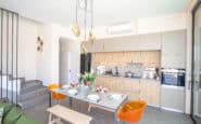 Modern Cyprus Villas Rentals with kitchen and dining area with minimalist design, sleek cabinets, vibrant chairs, and natural light.