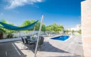 Tranquil outdoor dining area with pool and shade sail at Villa Blanco in Protaras.