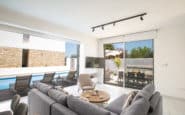 Modern and stylish indoor-outdoor living area with pool and dining space in Cyprus Protaras Villa Rentals.