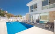 Luxurious modern Cyprus Protaras Villa Rentals with inviting pool, sun loungers, and blue sky.