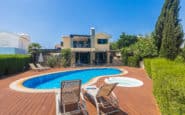 Luxurious Mediterranean villa with pool, deck, sunbeds, jacuzzi, and lush greenery for rent in Protaras.