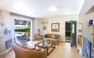 Cozy living room with patio doors, fireplace, and entertainment setup in rustic villa.