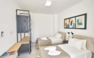 Modern minimalist bedroom with twin beds, elegant decor, and colourful wall art in villa in Cyprus Ayia Napa