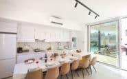 Ayia Napa Villas with Modern kitchen and dining area with sleek white design, bifold doors, and garden access.