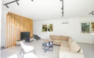 Ayia Napa Villas with Modern living room with minimalist design, beige sofa, black coffee table, and sleek lighting.