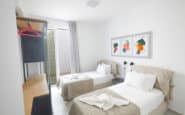 Modern Ayia Napa villas with twin bedroom with elegant decor, artworks, and functional workspace in Villa Jade, Cyprus.