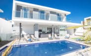 Modern white villa with pool, sunbeds, and shade in Protaras Cyprus