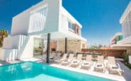 Luxurious modern villa with pool, sun loungers, and white facade in Ayia Napa Villa