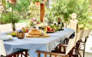 Outdoor dining table with chairs on a patio overlooking a garden at Villa Palms View in Limassol.