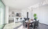 Cyprus villa rental offering modern kitchen and dining area with minimalist design, natural light, and elegant decor.