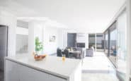 Protaras modern open-concept living area with kitchen island, dining space, and outdoor access.