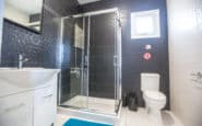 Modern monochrome bathroom with sleek shower, vanity unit, and toilet in Cyprus villa.