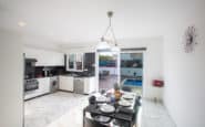 Modern minimalist kitchen and dining area in Protaras villa with sleek black and white design.