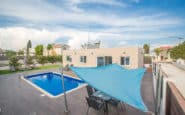 Luxurious poolside dining area at modern villa with shade sail in Protaras.