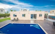 Modern single-story Villas in Protaras with pool and outdoor dining area in a suburban neighbourhood.