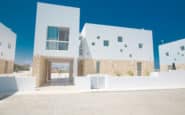 Modern white housing complex with minimalist design, stone cladding, and communal spaces in Protaras.